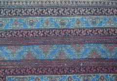 A close-up of a vintage Afghan Turkmen rug featuring intricate geometric patterns in wool.