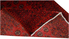 A vintage handwoven Afghan Turkmen rug featuring a red field with repeating geometric motifs.