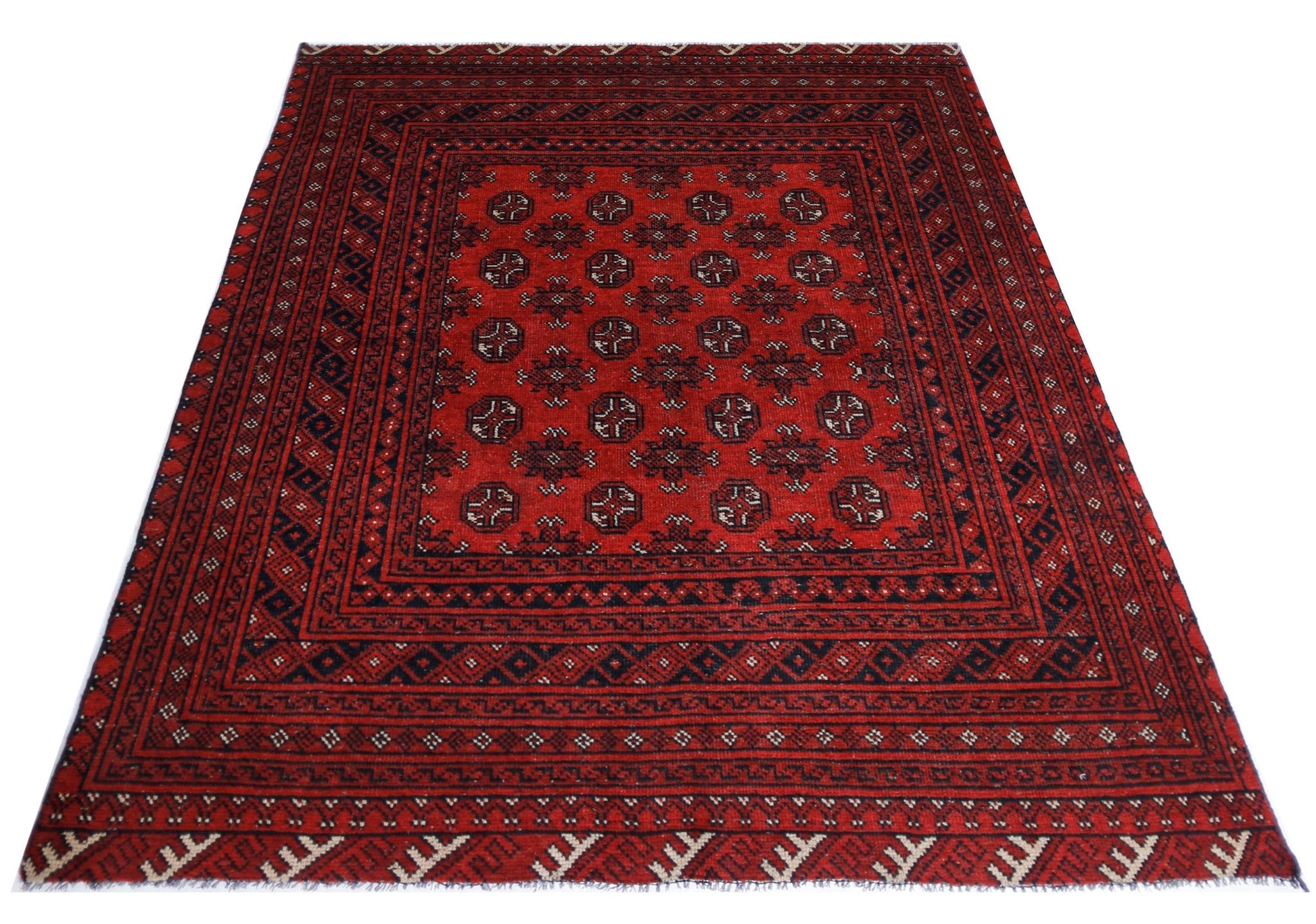 A handwoven vintage Afghan Turkmen rug featuring a repeating geometric pattern in red and black.
