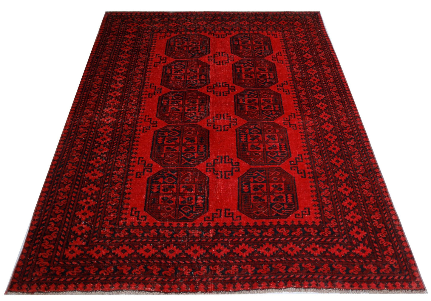 A vintage handwoven Afghan Turkmen rug featuring dark red octagonal motifs on a red background.