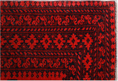 A vintage Afghan Turkmen rug featuring traditional geometric patterns in deep red and black.