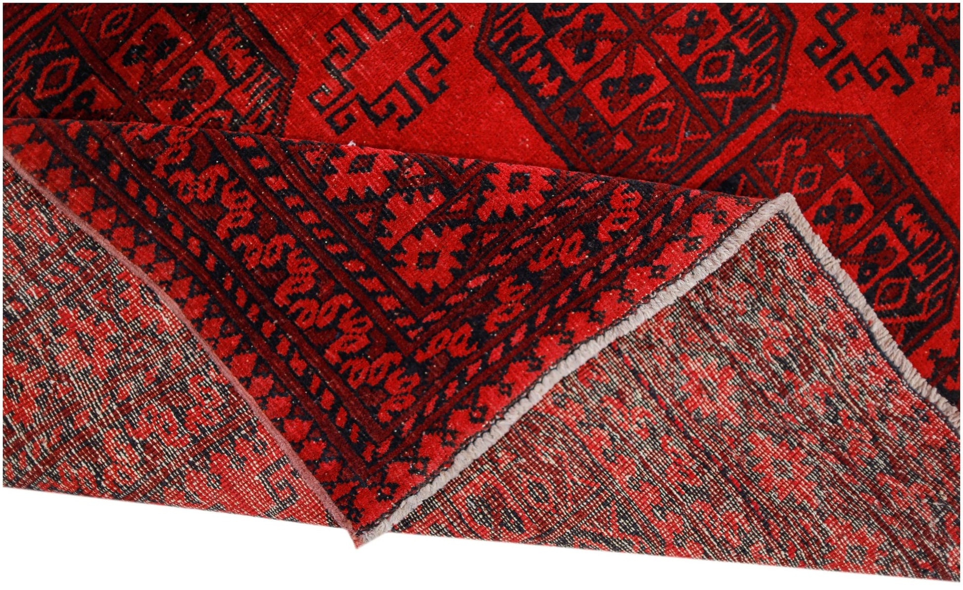 A vintage handwoven Afghan Turkmen rug featuring a geometric pattern in deep red and black wool.