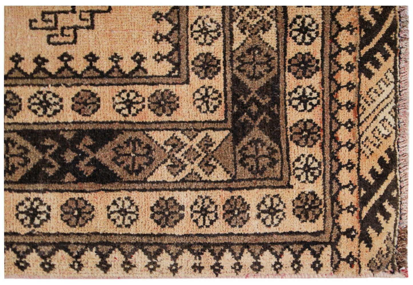 A close-up of a vintage Afghan Turkmen rug featuring geometric patterns in natural wool tones.
