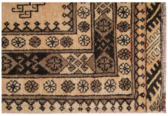 A close-up of a vintage Afghan Turkmen rug featuring geometric patterns in natural wool tones.
