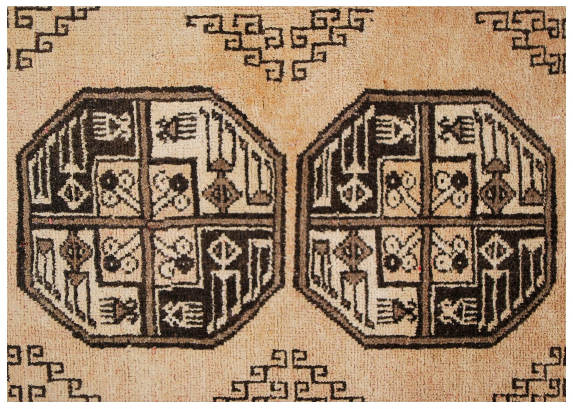 A vintage Afghan Turkmen rug featuring geometric octagonal motifs in dark brown on a natural wool background.