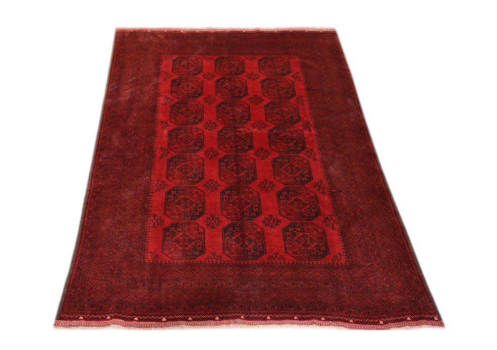 A vintage handmade Afghan Turkmen rug featuring a repeating octagonal pattern in deep red and black.