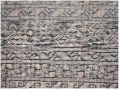 A vintage Afghan Turkmen rug featuring intricate geometric patterns in muted brown and tan tones.