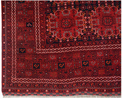 A vintage Afghan Turkmen rug featuring a deep red field with geometric elephant foot motifs.