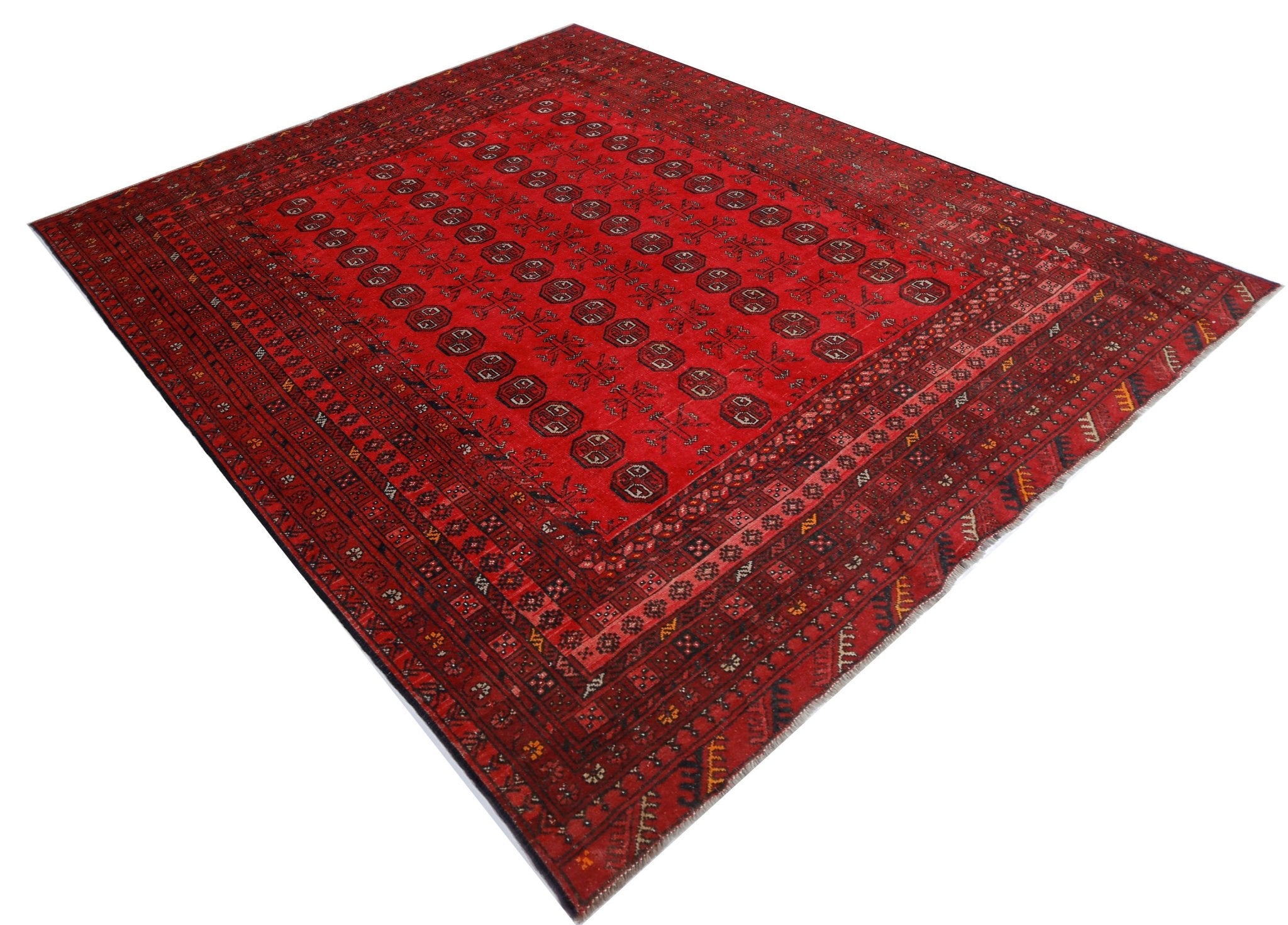 A vintage handmade Afghan Turkmen rug featuring a deep red field with repeating geometric motifs.
