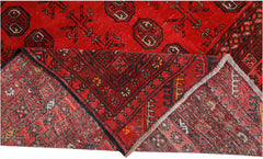 A vintage handmade Afghan Turkmen rug featuring a red field with geometric patterns.