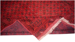 A vintage handmade Afghan Turkmen rug featuring a red field with repeating elephant foot motifs.