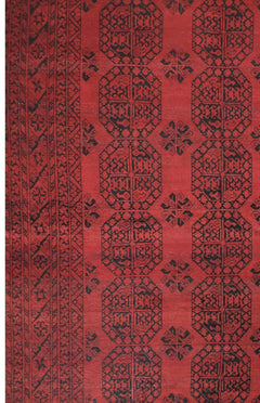 A vintage Afghan Turkmen rug featuring a repeating geometric octagonal pattern in red and black.