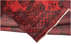 A vintage Afghan Turkmen rug featuring a red field with black geometric elephant foot motifs.
