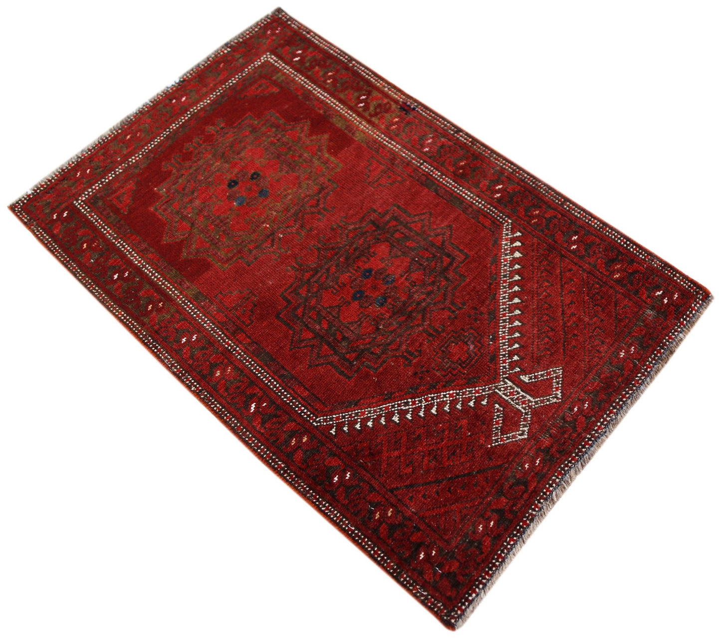 A vintage handmade Afghan Turkmen rug featuring two dark red geometric medallions on a red field.