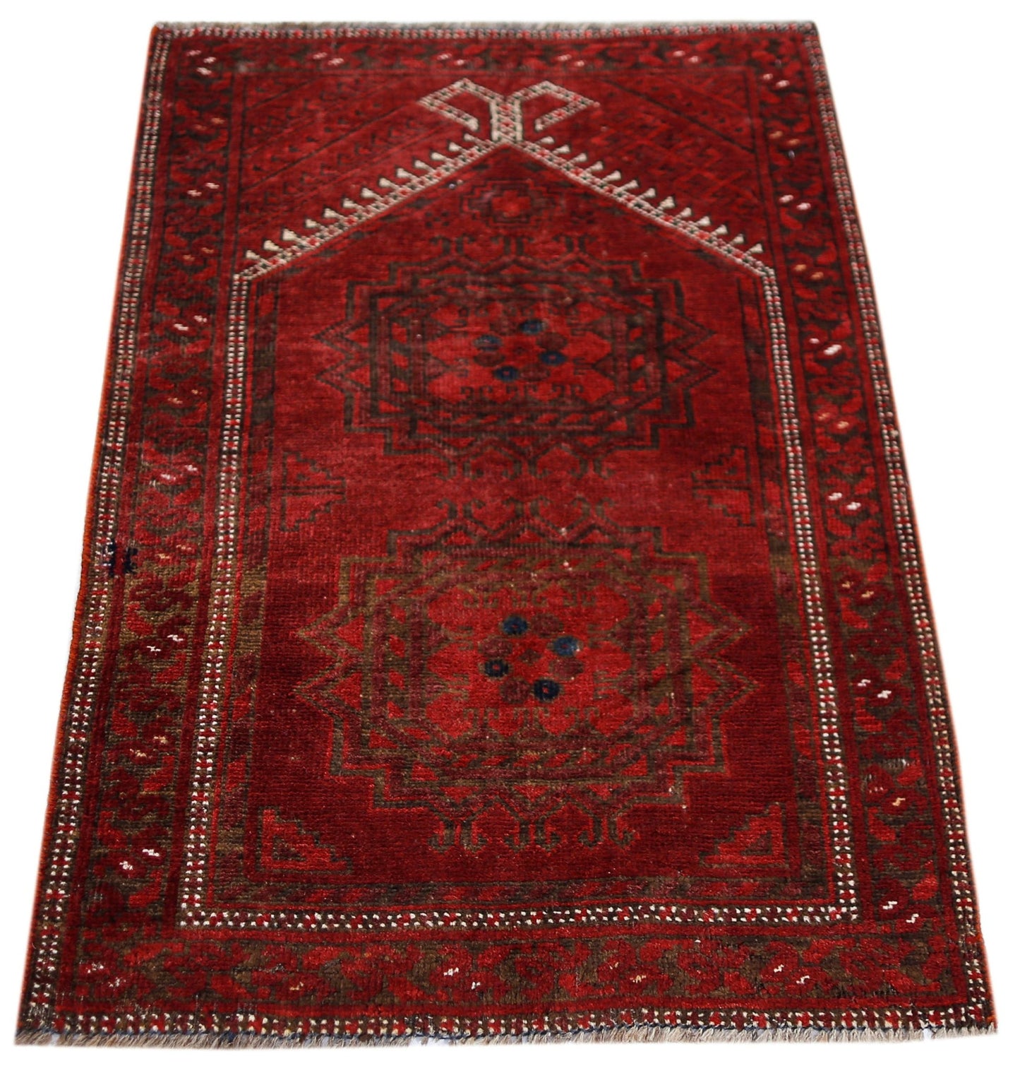 A vintage handmade Afghan Turkmen wool rug featuring two dark geometric medallions on a red field.