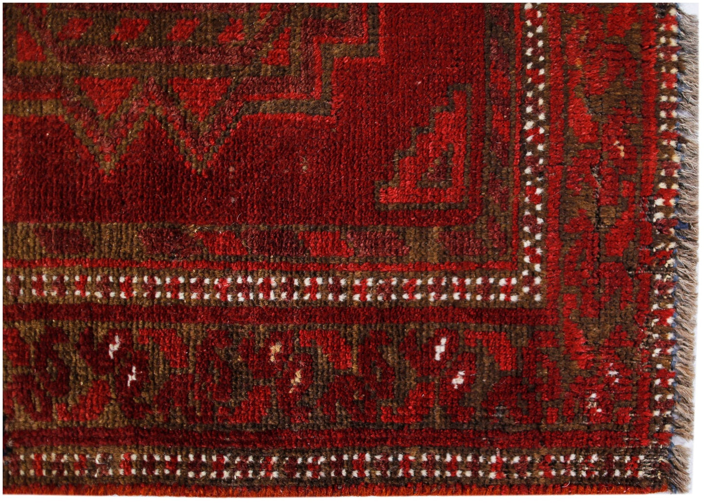 A vintage Afghan Turkmen rug featuring a geometric red and brown pattern with a fringed edge.