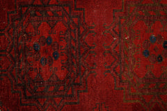 A vintage handmade Afghan Turkmen rug featuring traditional geometric patterns in deep red wool.