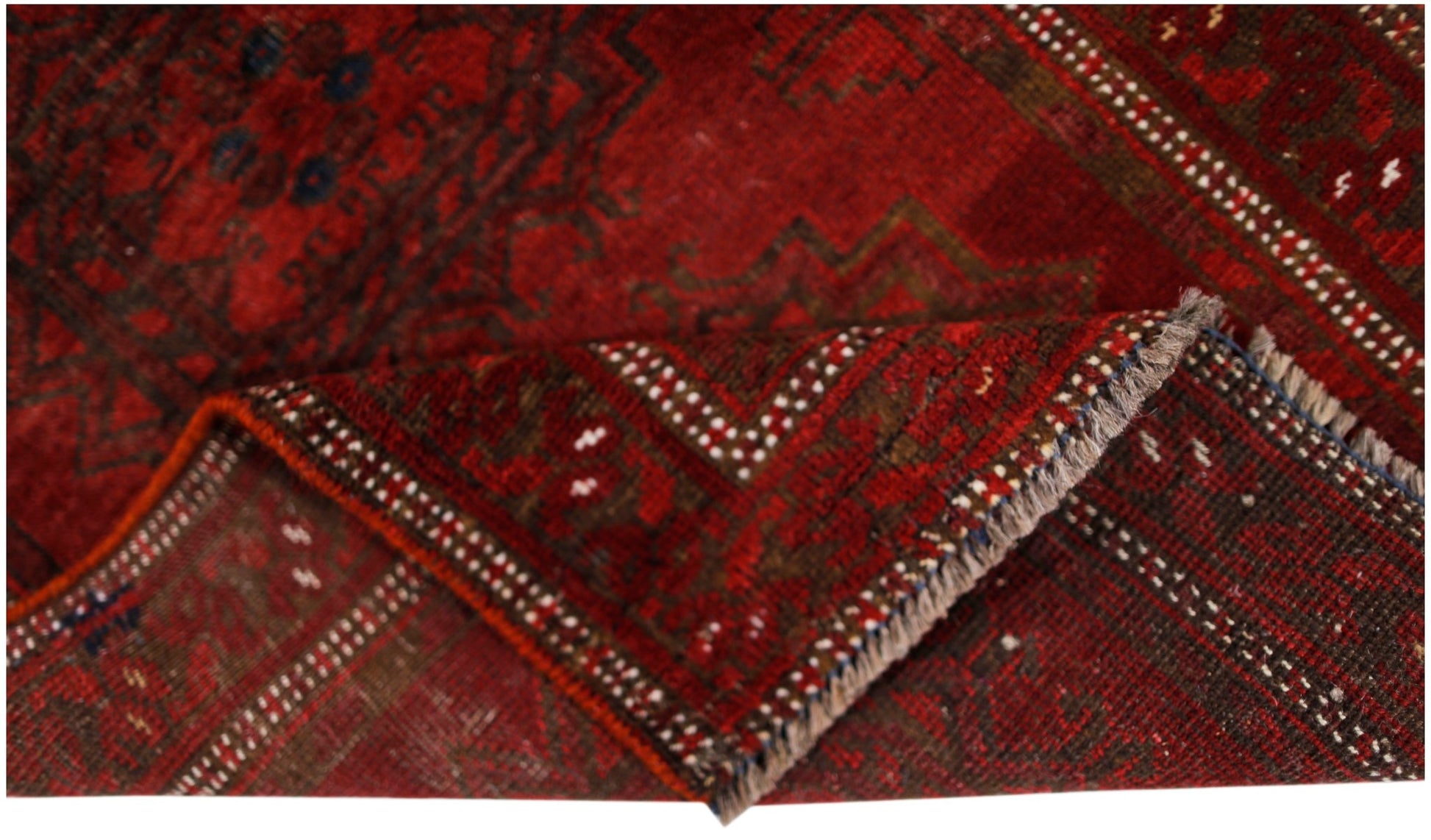 A vintage handmade Afghan Turkmen wool rug featuring a deep red geometric pattern.