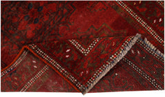 A vintage handmade Afghan Turkmen wool rug featuring a deep red geometric pattern.
