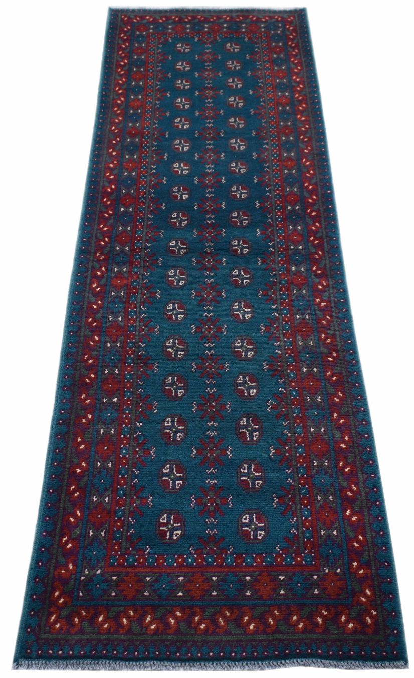 A handmade vintage Afghan Turkmen runner rug featuring geometric patterns in teal and red.