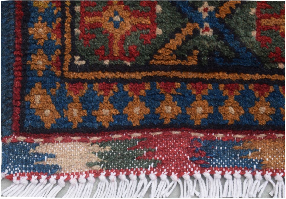 A close-up of a handmade vintage Afghan Turkmen runner featuring geometric patterns in wool.