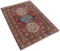 A handwoven vintage Caucasian rug featuring geometric patterns in red, blue, and beige tones.
