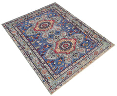 A vintage handwoven Caucasian rug featuring geometric patterns in blue, red, and cream tones.