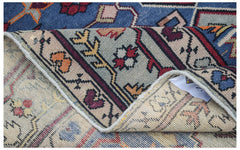 A vintage handwoven Caucasian wool rug with a blue and beige geometric pattern.