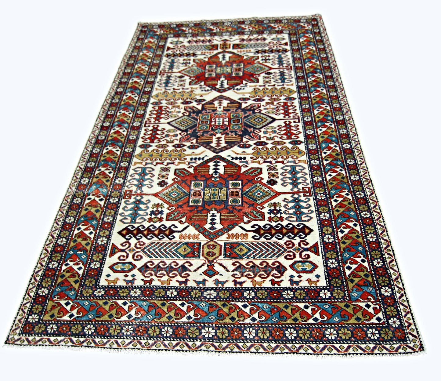 A handwoven vintage Caucasian rug featuring geometric patterns in red, blue, and cream tones.