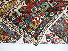 A handwoven vintage Caucasian wool rug featuring intricate geometric patterns in vibrant colors.