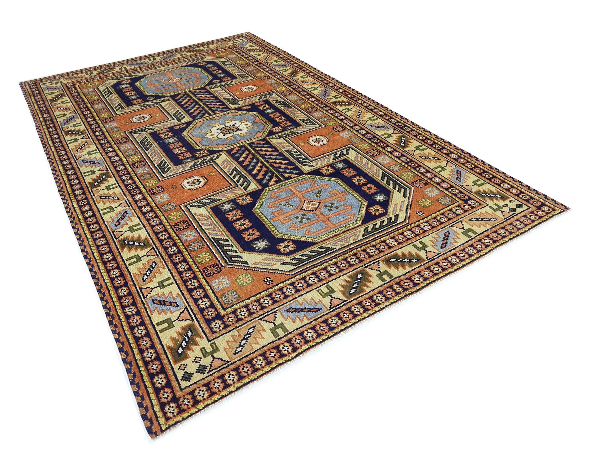 A vintage Caucasian rug featuring geometric patterns in blue, orange, and cream tones.