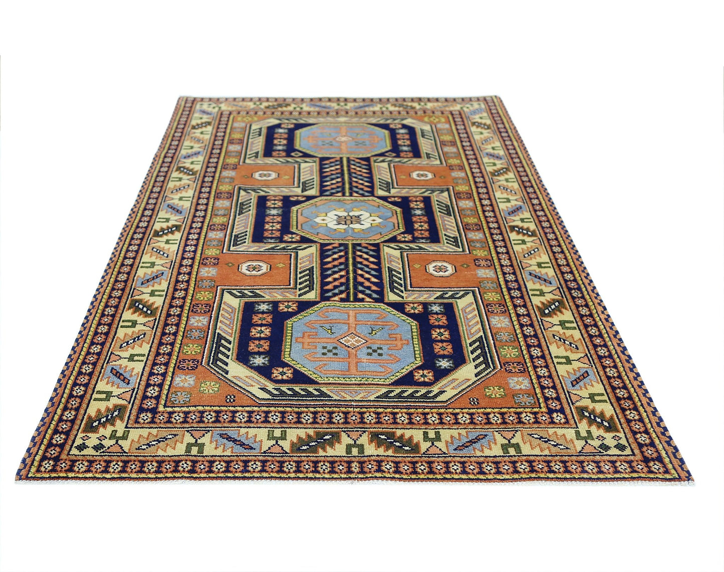 A rectangular vintage Caucasian rug featuring geometric patterns in blue, orange, and cream tones.