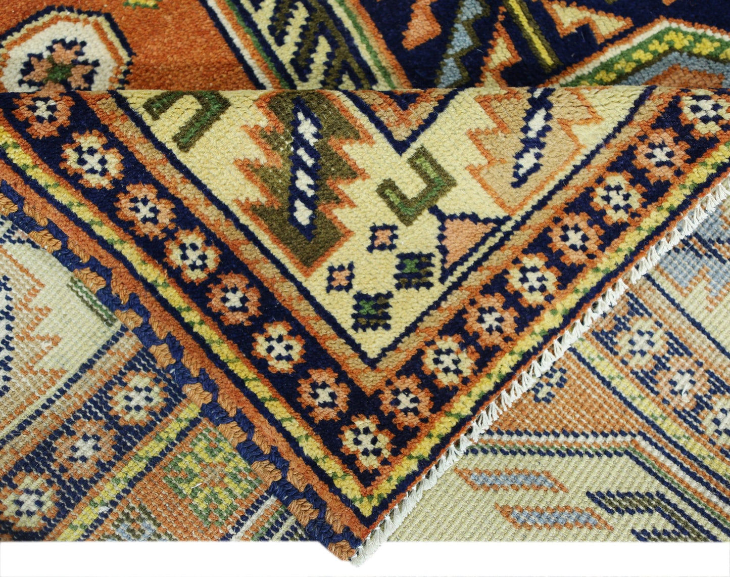 A vintage Caucasian rug featuring intricate geometric patterns in vibrant orange, blue, and cream.
