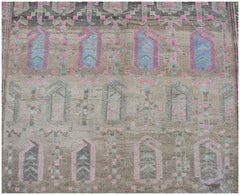 A vintage handwoven Persian rug featuring a repeating geometric pattern in muted brown and pink.