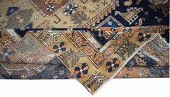 A handwoven vintage Caucasian rug featuring geometric patterns in blue, orange, and tan wool.