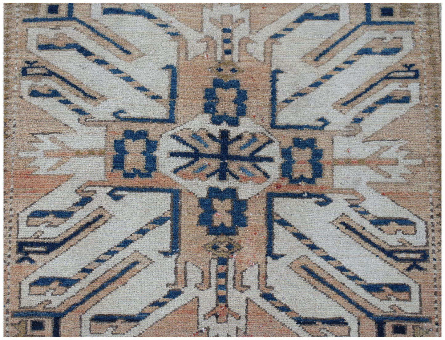 A vintage Caucasian runner featuring a traditional eagle Kazak pattern in blue, white, and tan.