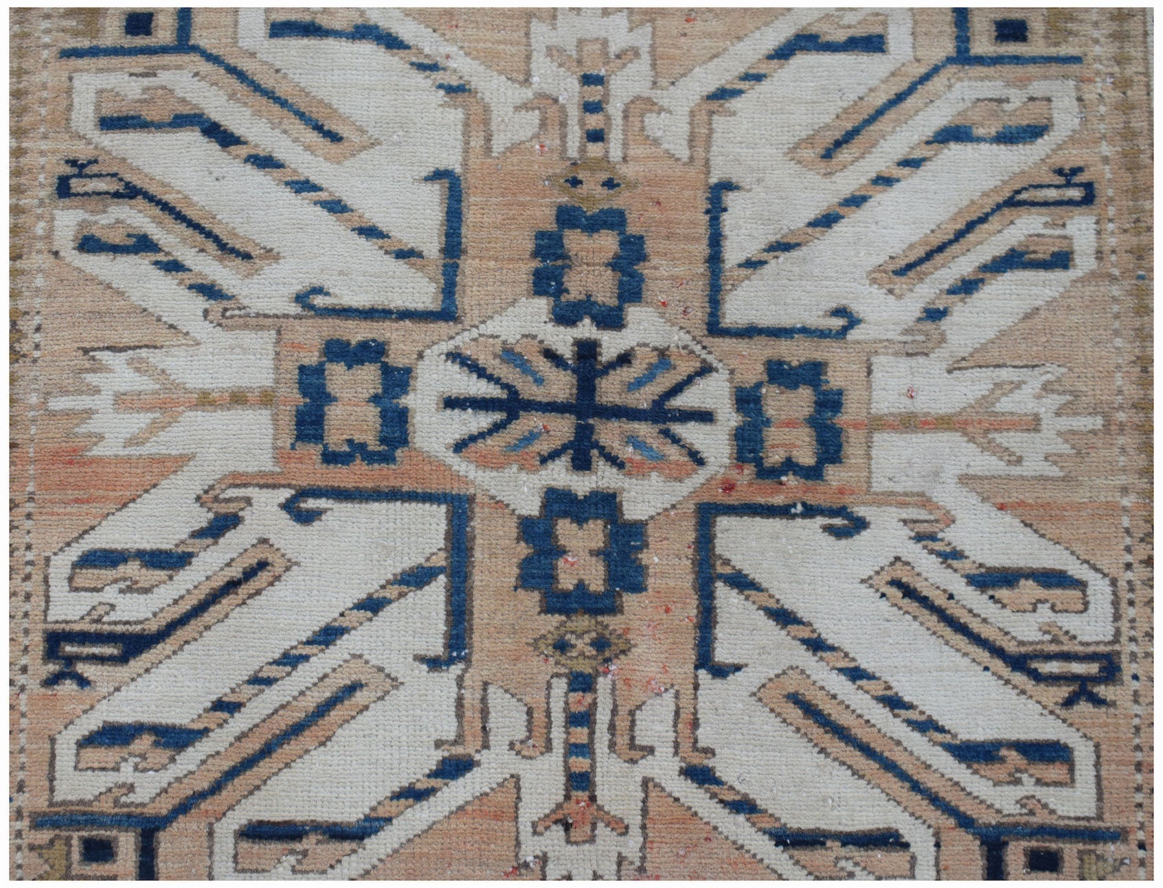 A vintage Caucasian runner featuring a traditional eagle Kazak pattern in blue, white, and tan.