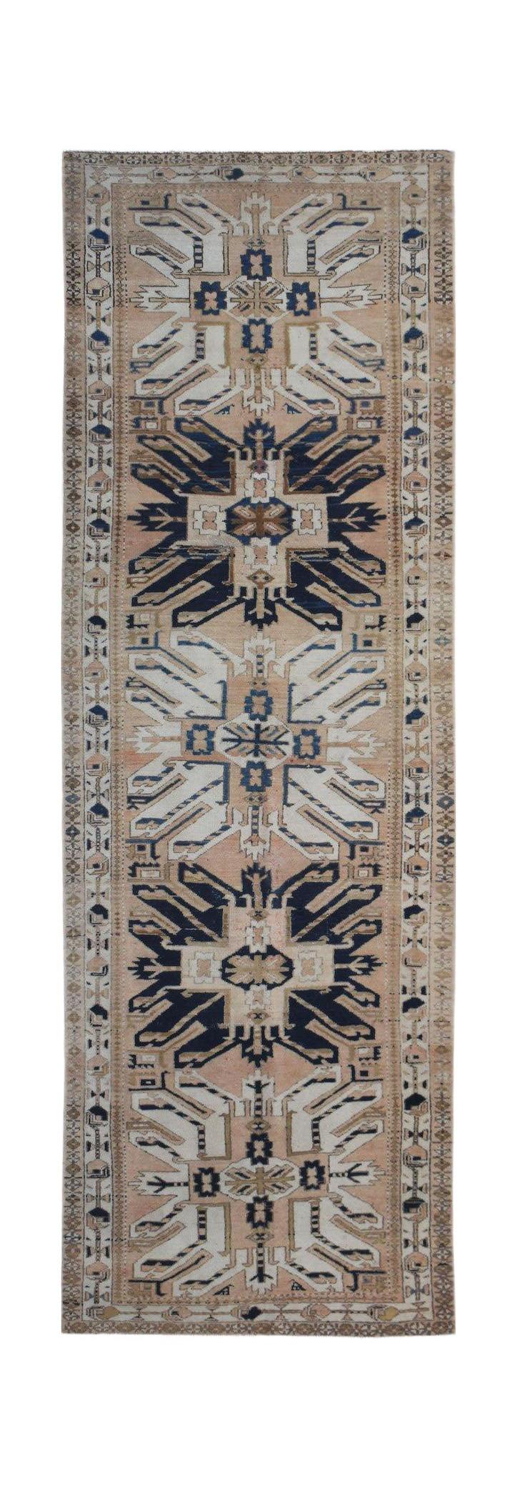 A vintage handmade Caucasian runner rug featuring a traditional eagle Kazak pattern in blue and tan.