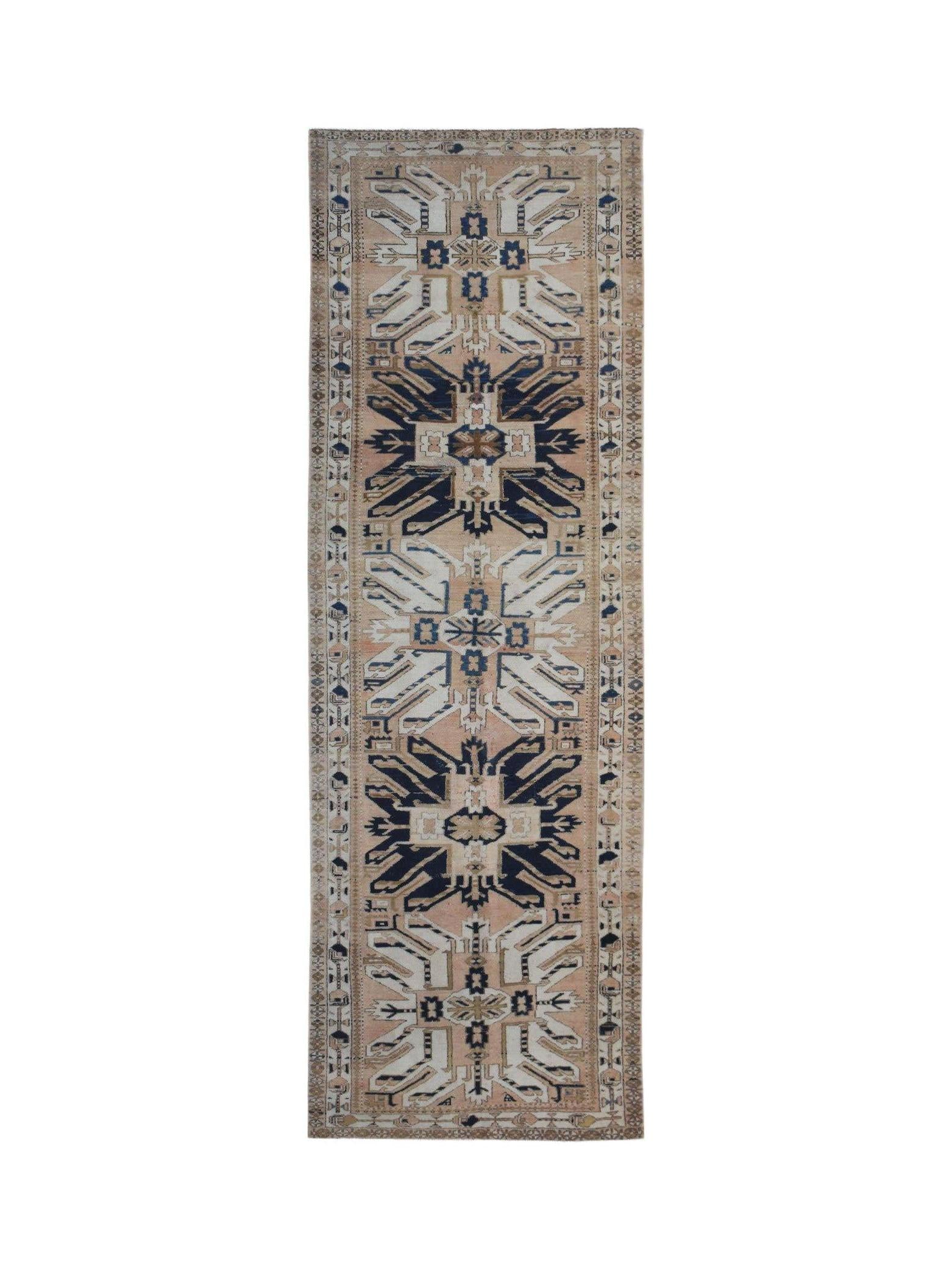 A vintage handmade Caucasian runner rug featuring a traditional eagle Kazak pattern in blue and tan.