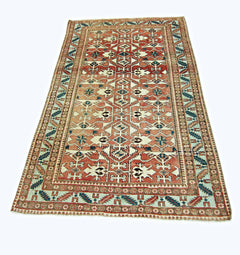 A rectangular vintage Persian rug featuring a geometric pattern in red, blue, and cream tones.