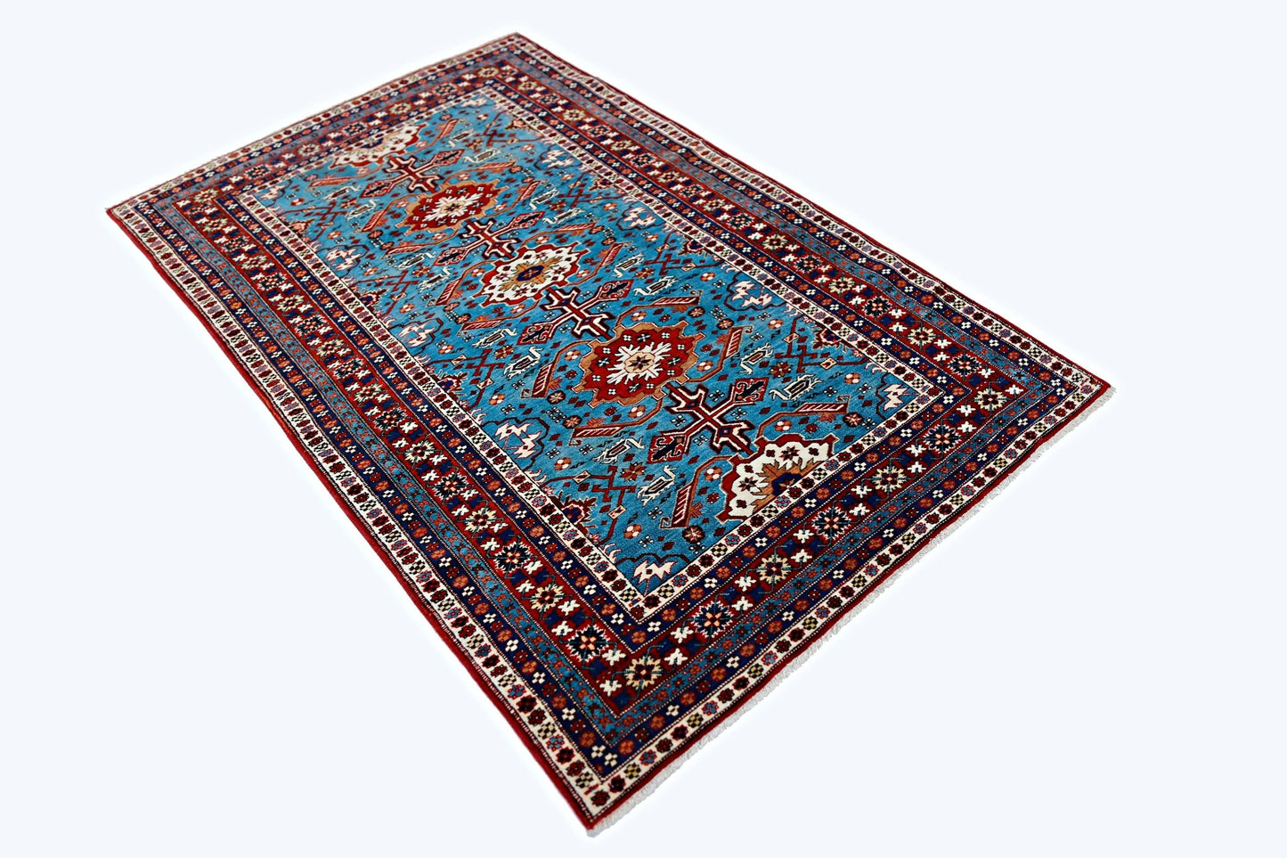 A vintage Caucasian Shirvan rug featuring intricate geometric patterns in blue, red, and cream.