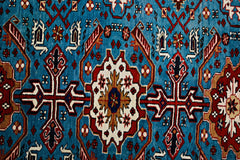 A vintage Caucasian Shirvan rug featuring intricate geometric patterns in blue, red, and white.