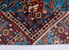 A vintage Caucasian Shirvan rug with intricate geometric patterns in blue, red, and cream.