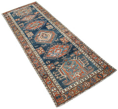 A vintage Caucasian Shirvan runner featuring geometric patterns in blue, red, and cream tones.