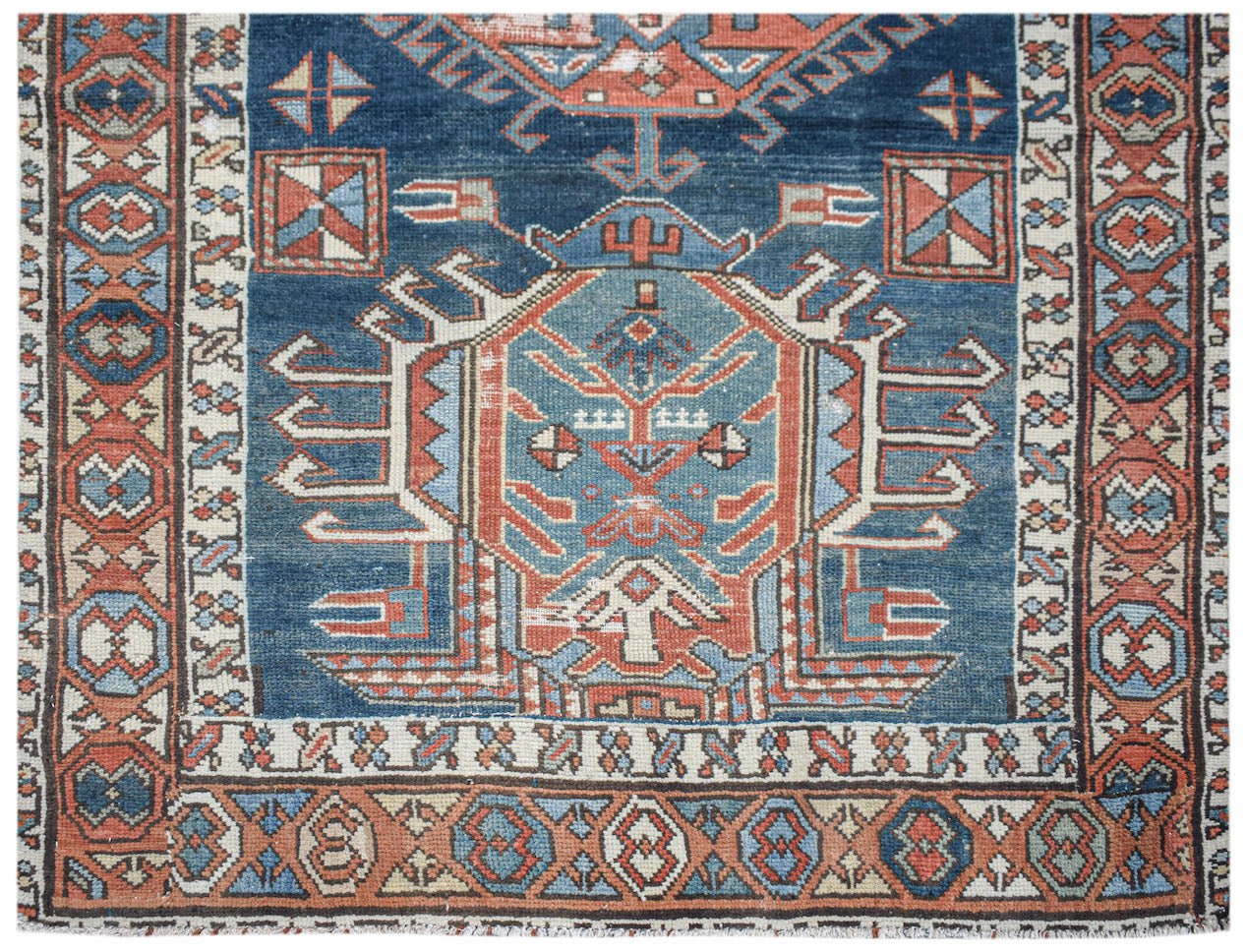 A vintage handwoven Caucasian Shirvan runner featuring a geometric blue and red medallion pattern.