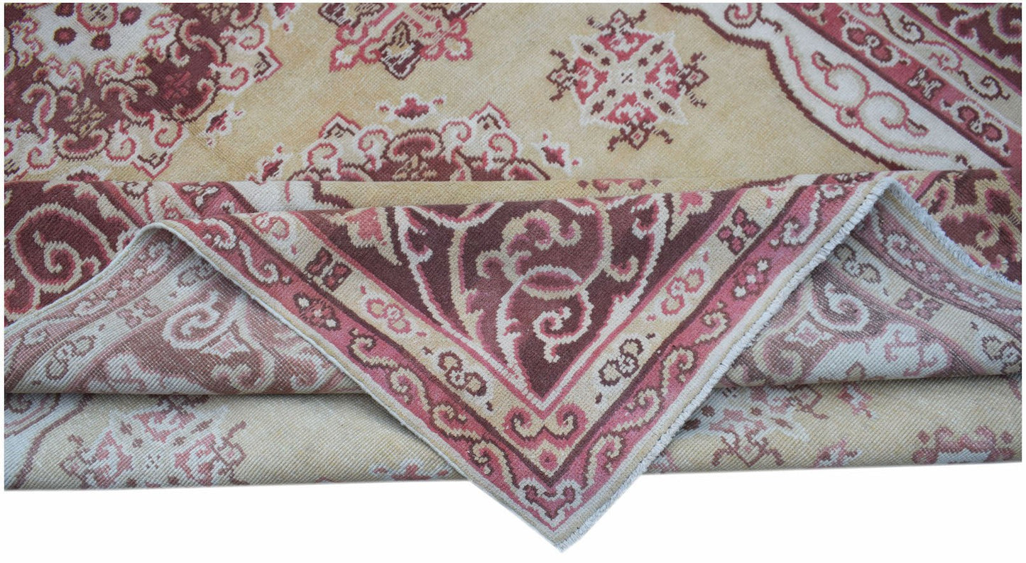 A vintage Chinese Khotan rug featuring a floral medallion pattern in shades of red and beige.