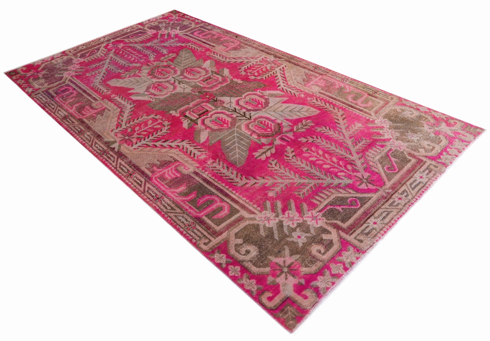 A vintage handwoven Khotan rug featuring a vibrant pink field with an intricate floral pattern.