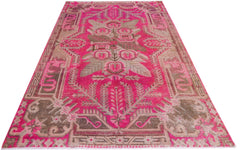 A vintage handwoven Khotan rug featuring an intricate pomegranate pattern in vibrant pink and brown.