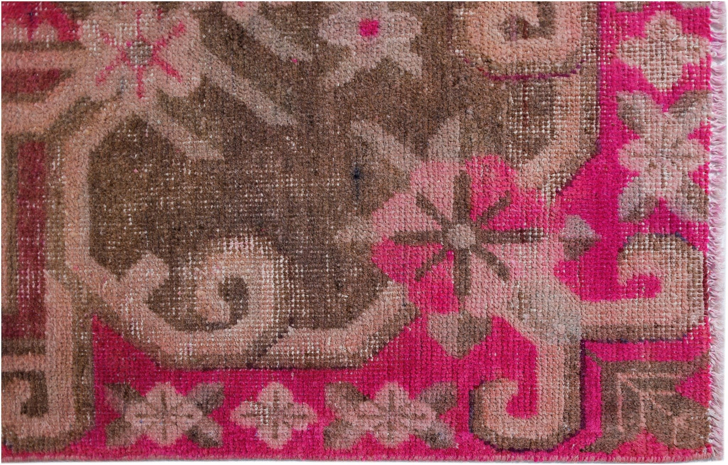 A vintage Chinese Khotan rug featuring an intricate pomegranate pattern in vibrant pink and brown.