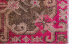A vintage Chinese Khotan rug featuring an intricate pomegranate pattern in vibrant pink and brown.
